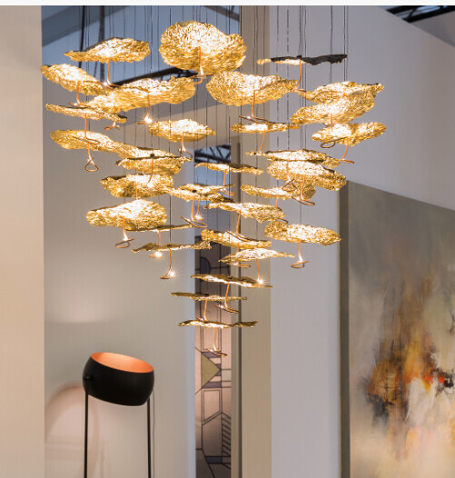 Hängende goldene Wolkenlampen über modernem Innenraum mit Wandkunst.