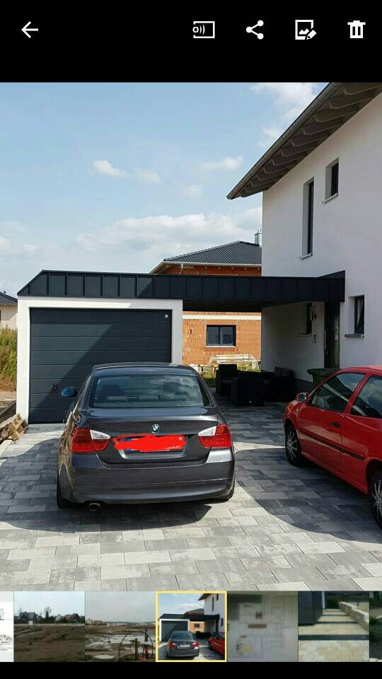 Außenansicht eines modernen Hauses mit Garage und geparkten Autos in der Einfahrt