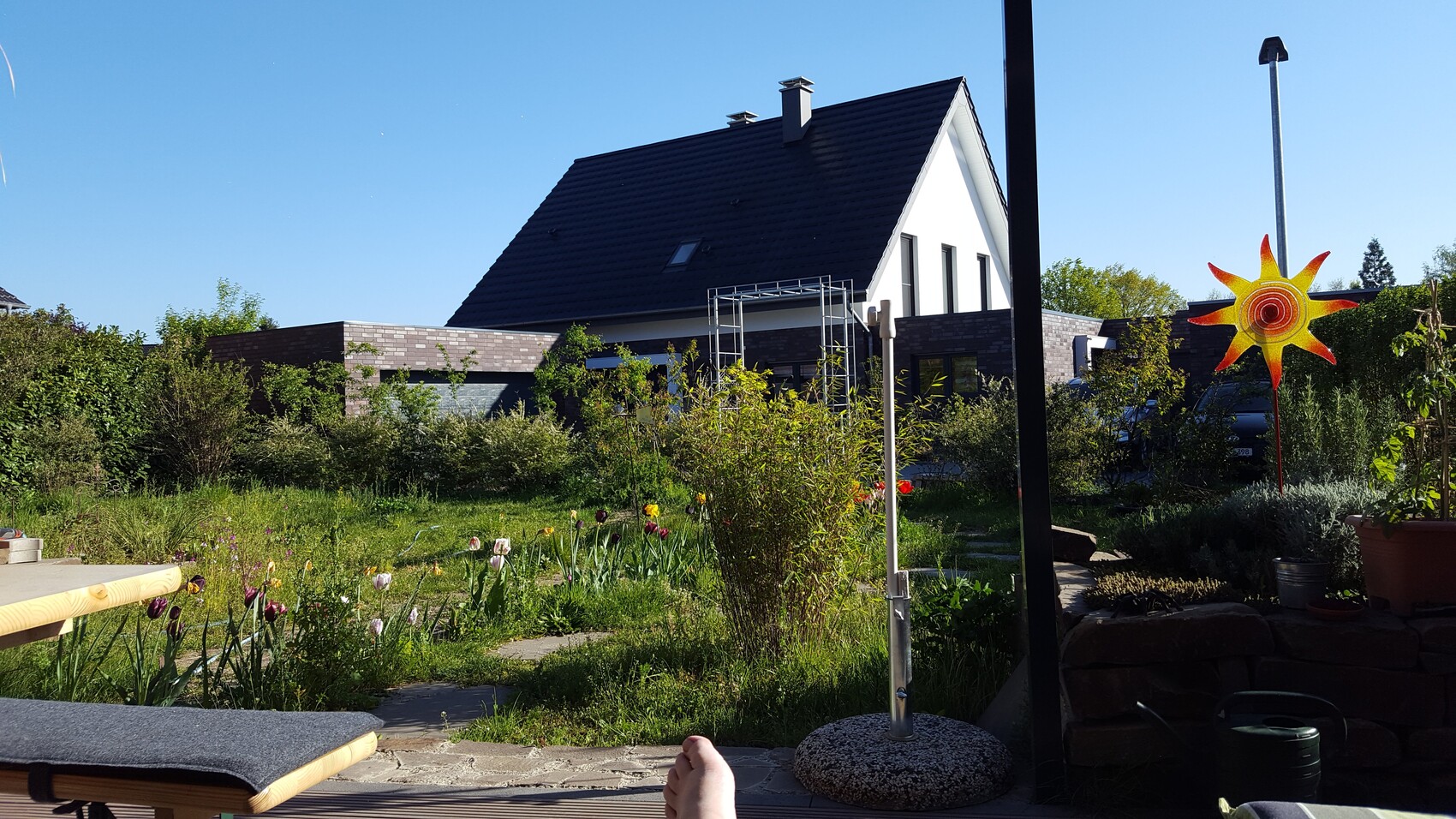 Moderne Hausfassade mit Garten und blauem Himmel