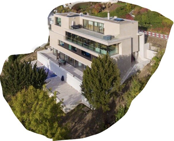 Moderne dreistöckige Villa mit großen Glasfronten auf Hanggrundstück, Terrasse und Pool.