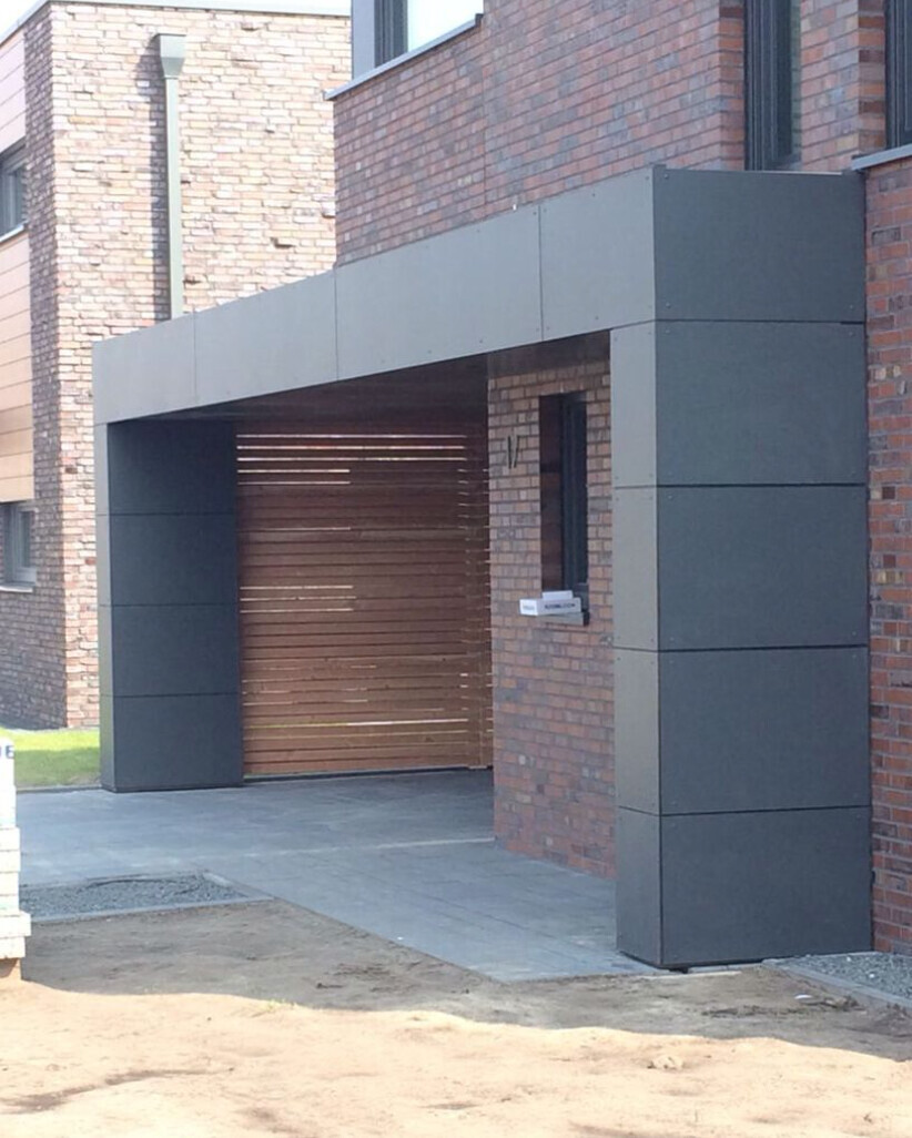 Moderne Hausfassade mit grauem Portico, Holz-Garagentor und Ziegelwänden