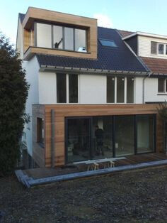 Moderne zweigeschossige Hausfassade mit Holzverkleidung, grossen Glasfronten und Terrasse