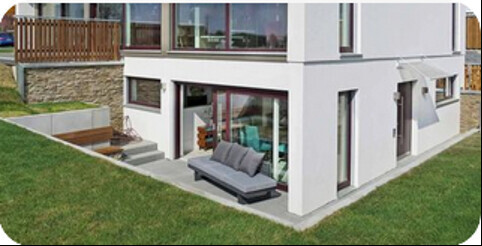 Außenansicht eines modernen Hauses mit weißer Fassade, Terrasse und Garten.