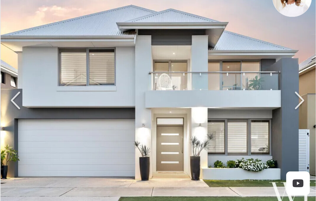 Modernes zweistöckiges Haus mit Garage, Eingangstür und Balkon mit Glasgeländer.
