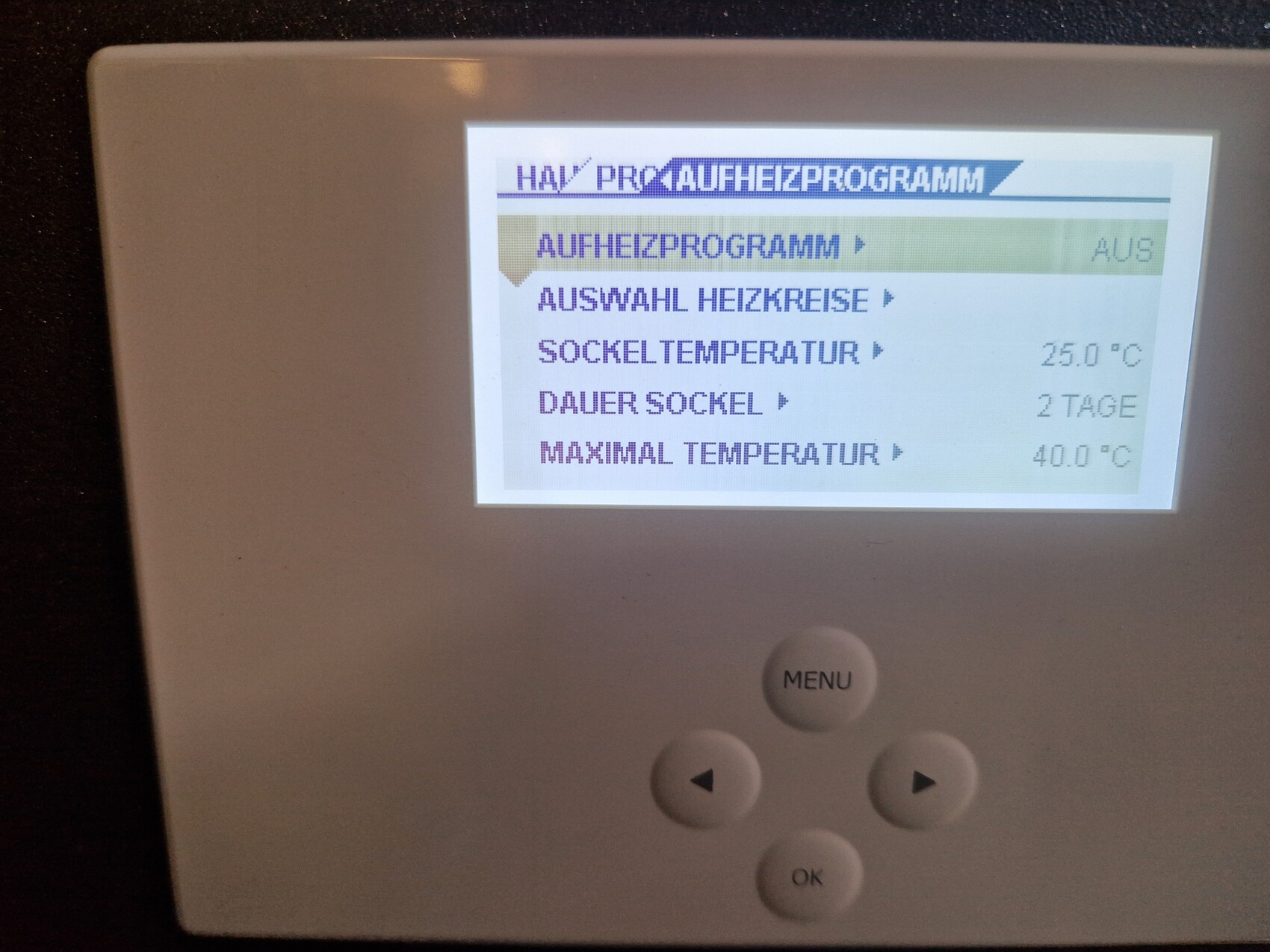 Thermostat mit Display zeigt Aufheizprogramm, Temperaturoptionen und Menüknopf