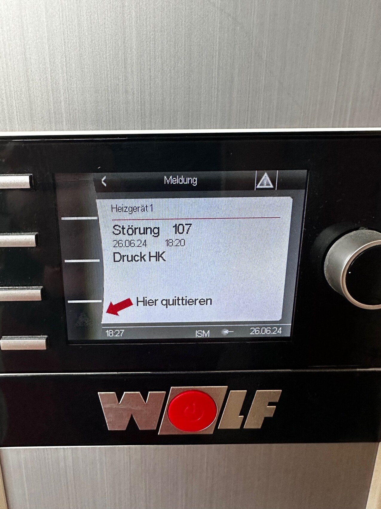 Wolf-Heizgerät-Display zeigt Störung 107, Druck HK; roter Pfeil mit "Hier quitieren".
