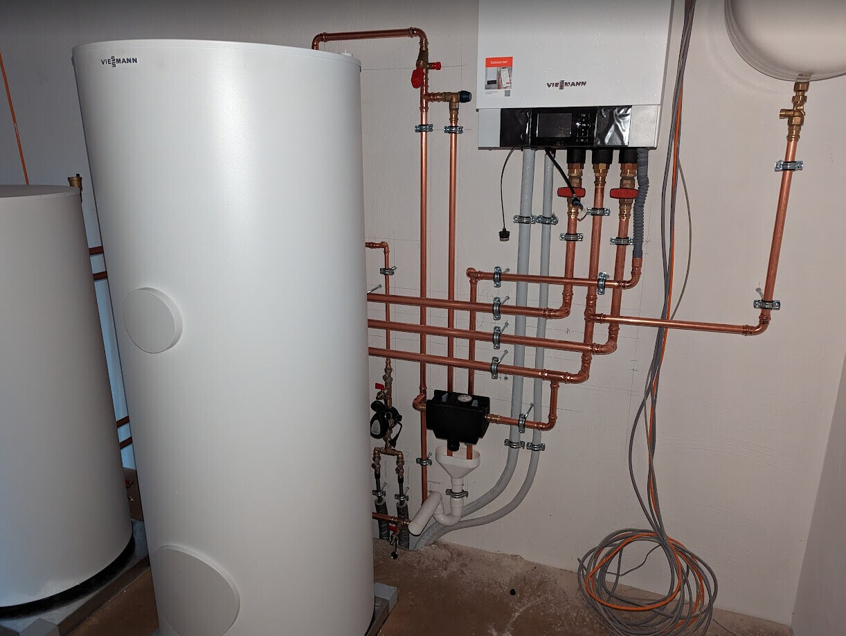 Großer Warmwasserspeicher und Heizungsanlage mit Kupferrohren, Ventilen und Steuereinheit