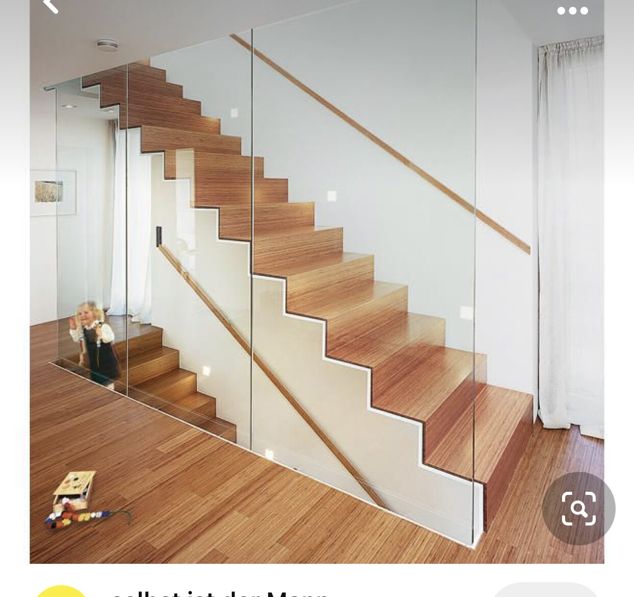 Moderne Holztreppe mit Glasgeländer im Wohnraum; Kind spielt links am Boden.