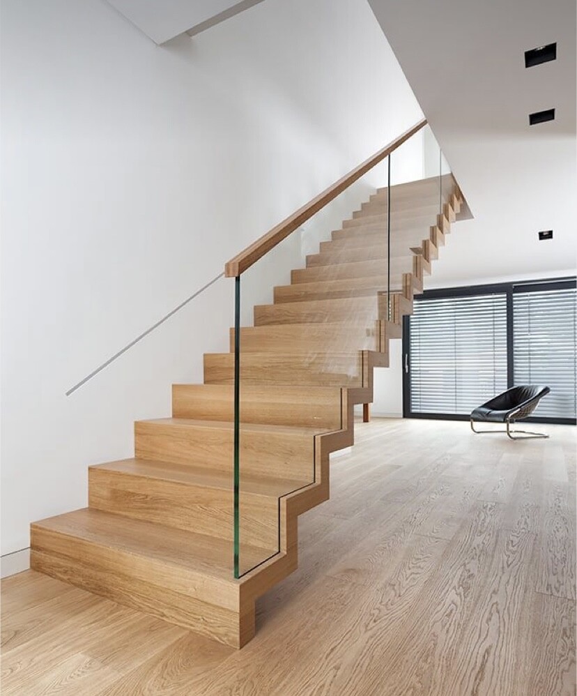 Moderne Holztreppe mit Glasgeländer in heller, offener Wohnlounge