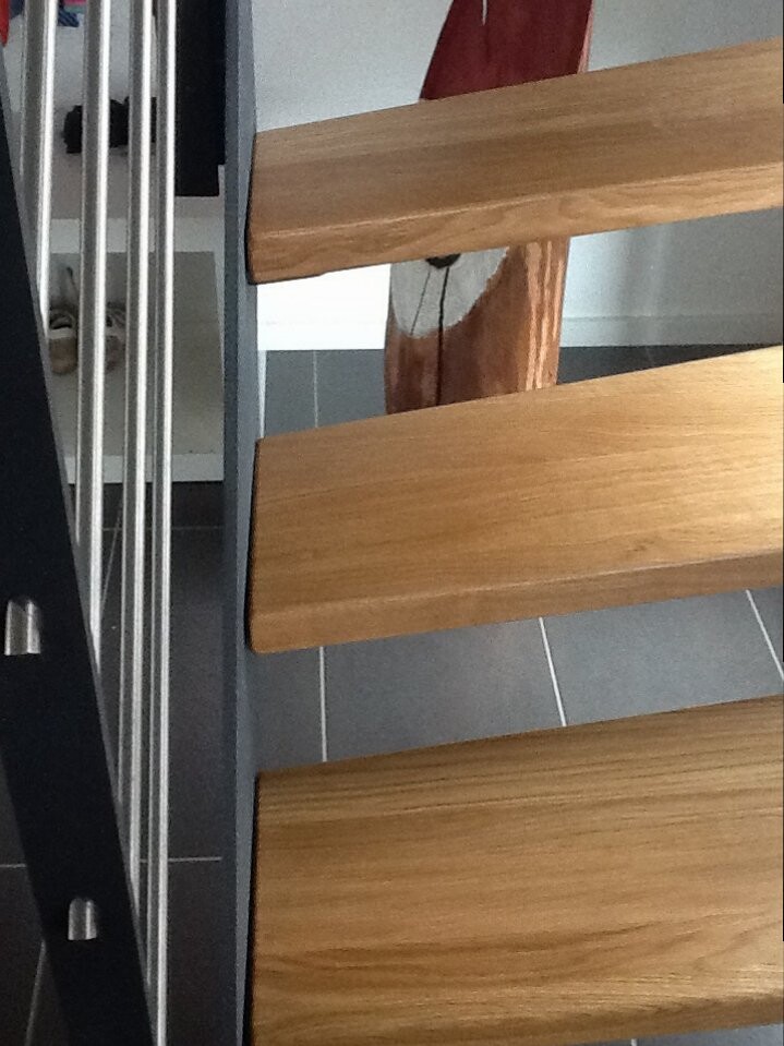 Moderne Holztreppe mit Metallgeländer im Innenbereich.