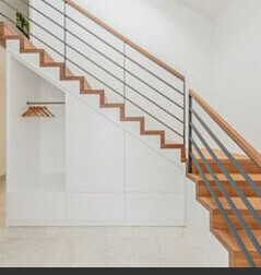 Weiße Innentreppe mit Holzhandlauf und Stauraum unter der Treppe