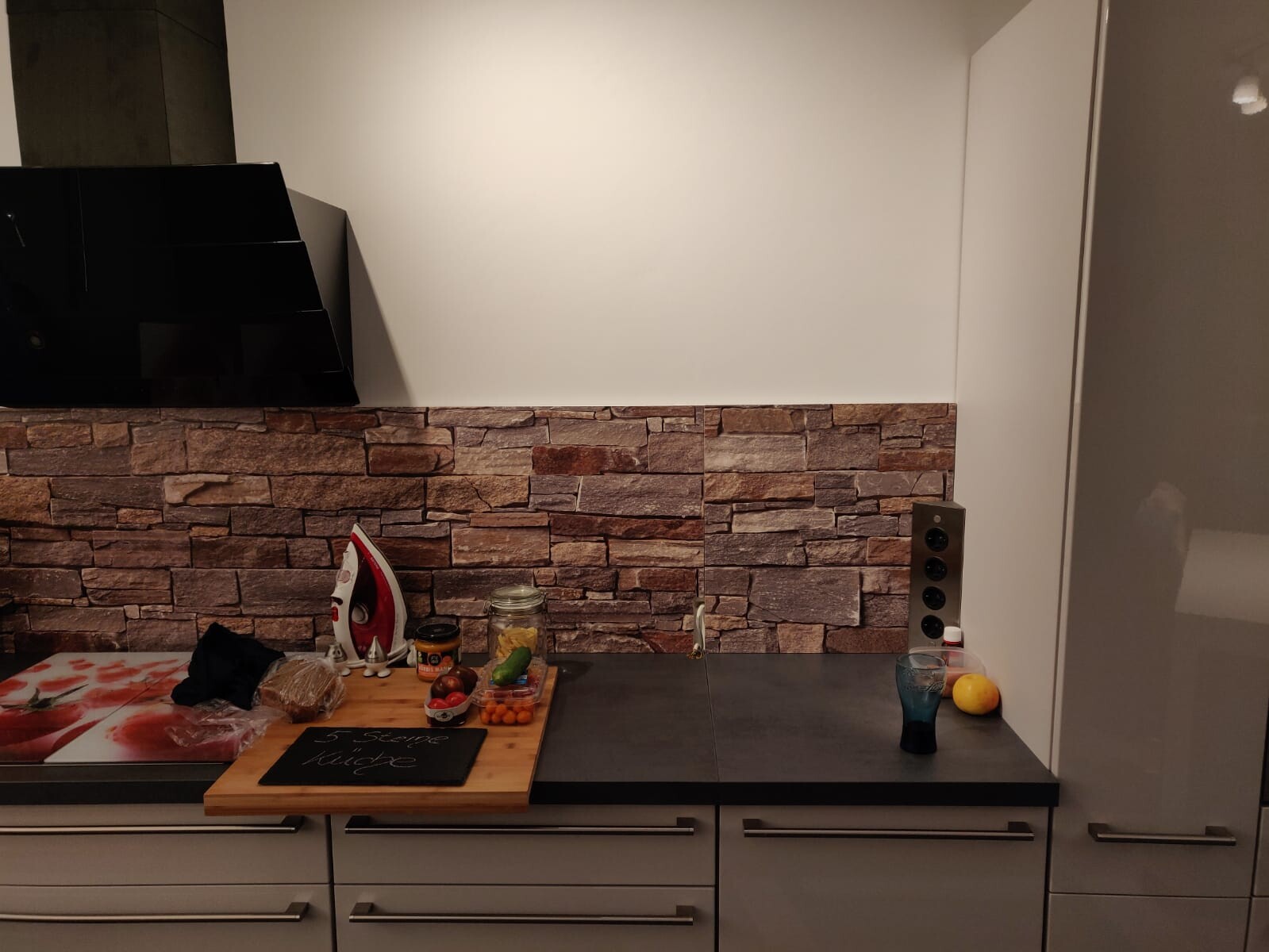 Moderne Küche mit Backstein-Wandverkleidung, Arbeitsplatte und Küchenzubehör