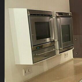 Moderne Küche mit zwei eingebauten Edelstahl-Doppelöfen über Arbeitsplatte