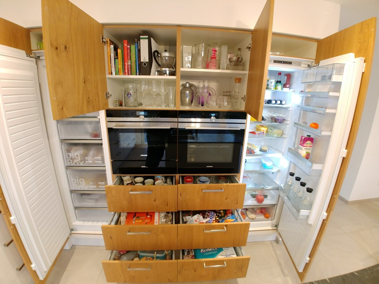 Moderne Küche mit Einbau-Backöfen, Holzfronten, offenen Regalen und offenem Kühlschrank