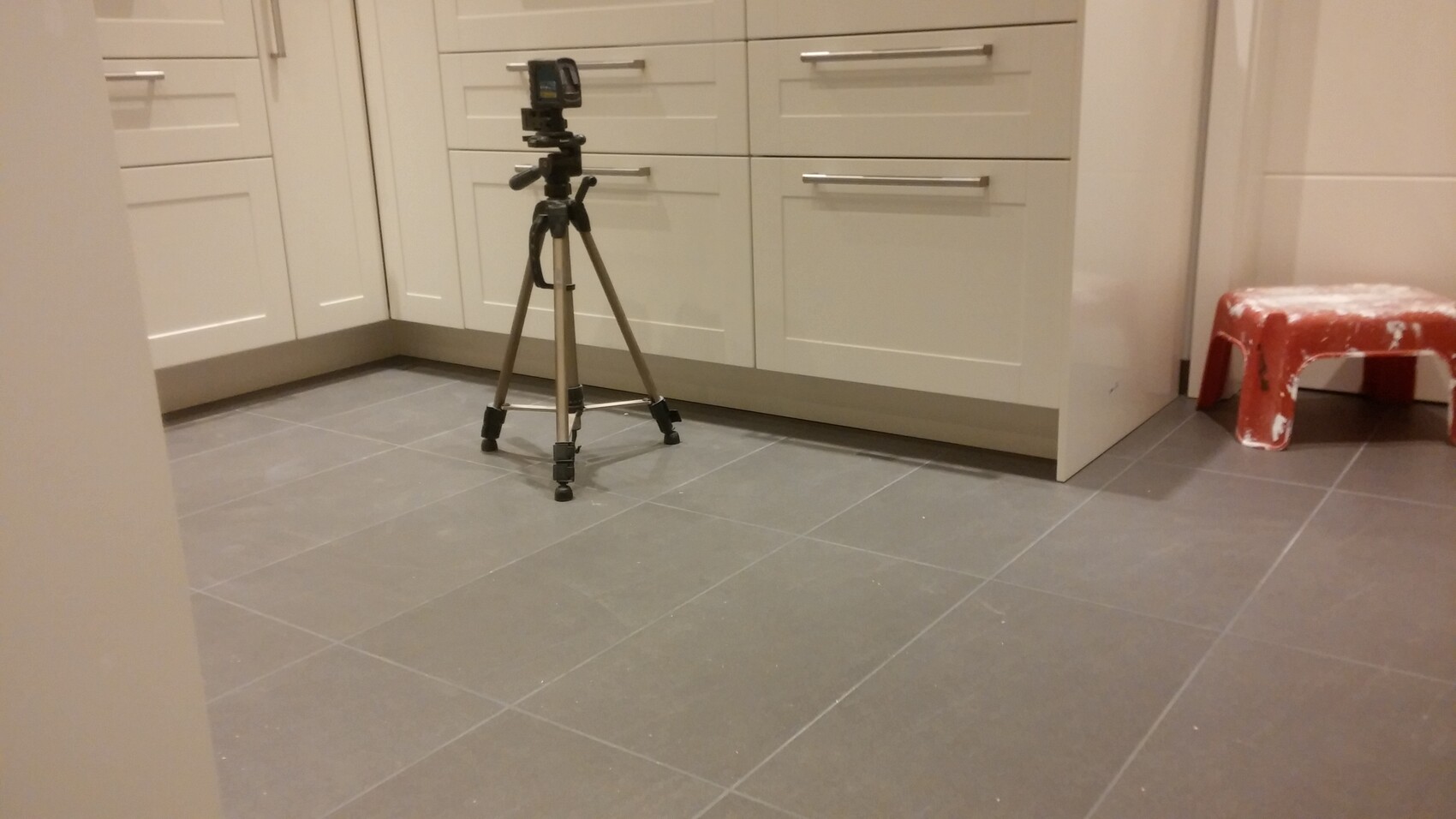 moderne-kueche-mit-grauen-fliesen-und-weissen-schaenken-tripod-im-kuechenbereich.jpg