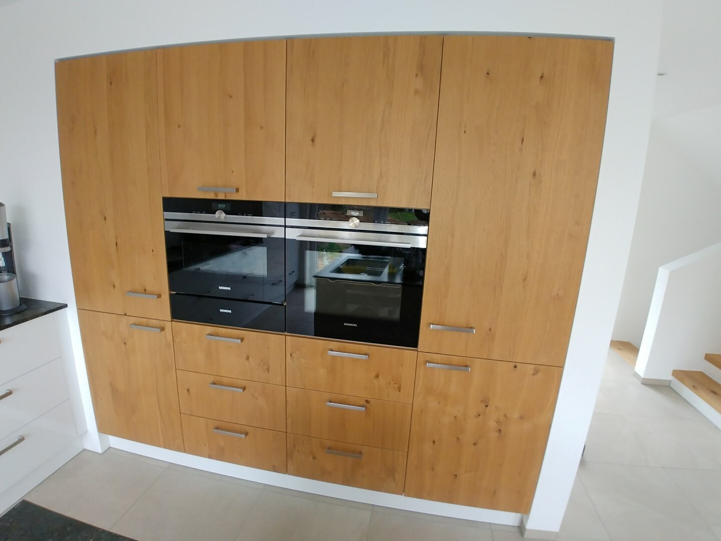 Küche mit Holzfronten und integrierten Siemens-Backöfen in einer modernen Küchenzeile
