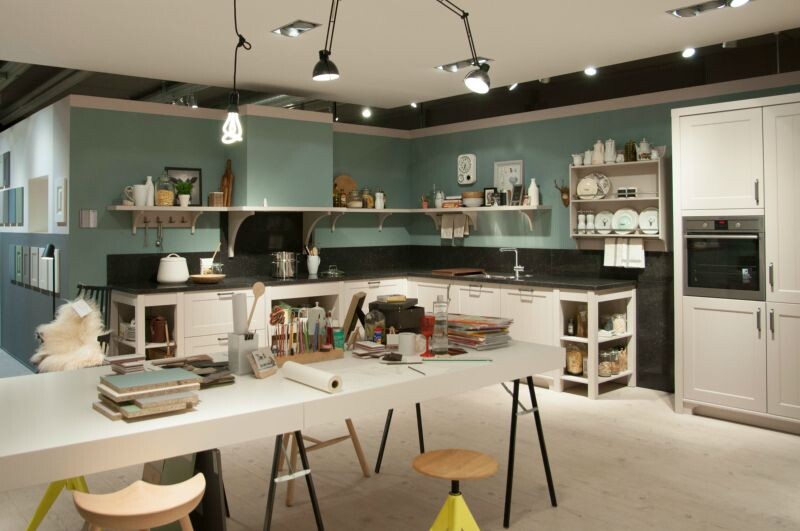 Moderne Küchenwerkstatt mit großer Arbeitsfläche, Regalen, Geräten und Küchenutensilien.