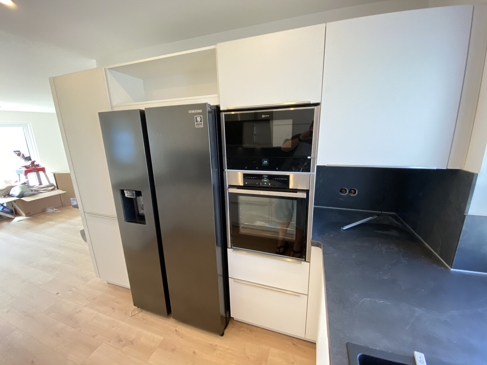 Küche mit Samsung Side-by-Side Kühlschrank integrierter Backofen/Mikrowelle dunkle Arbeitsplatte