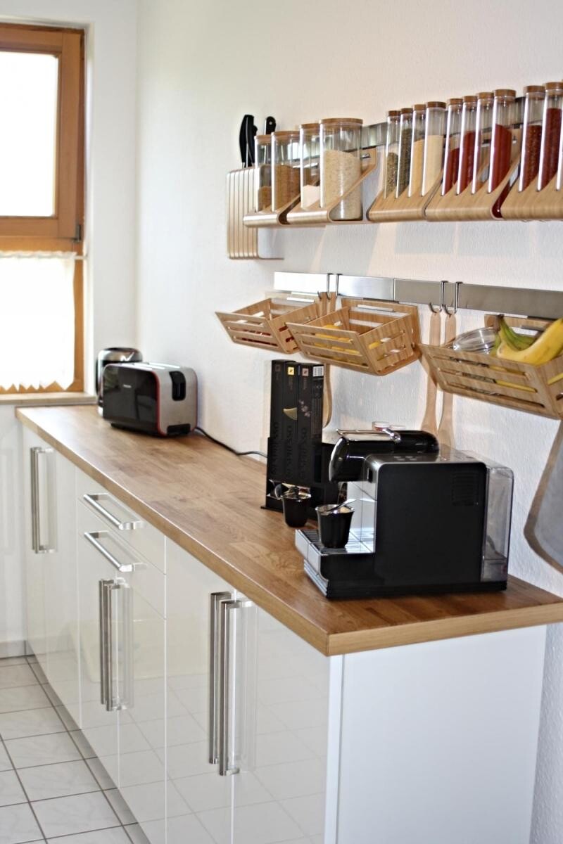 Küche mit Holzarbeitsplatte, Kaffeemaschine, Toaster und Gewuerzregal