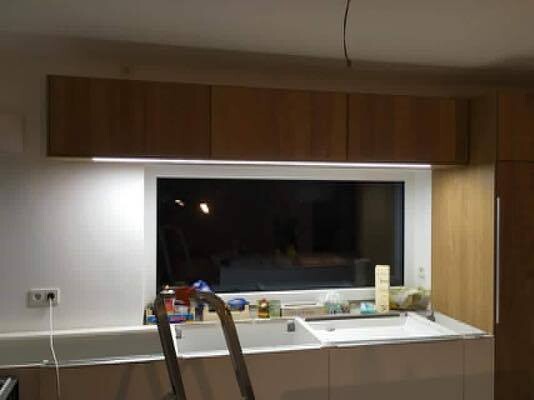 Küche im Umbau: Leiter vor dem Spülbecken, Werkzeuge und Materialien auf der Arbeitsfläche.