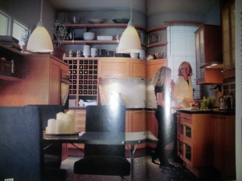 Moderne Küche mit Holzmöbeln, Esstisch, zwei Frauen in der Küche