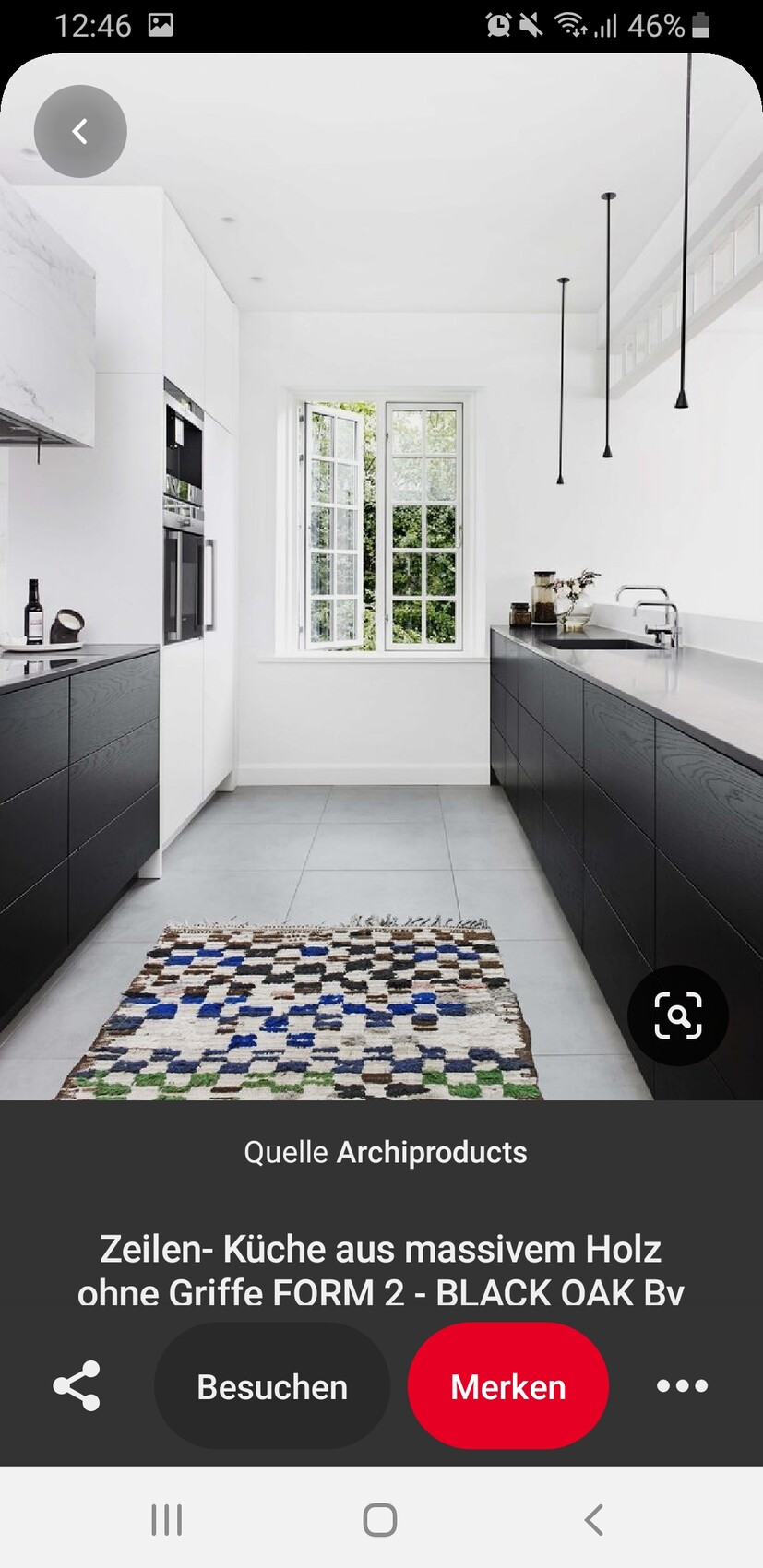 Moderne Küche: weiße Wände, schwarze Unterschränke, großes Fenster, farbiger Teppich.