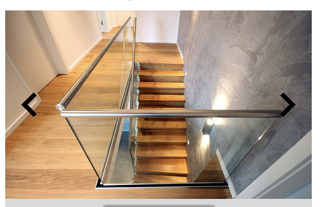 Moderne Holztreppe mit Glas- und Metallgeländer in hellem Treppenhaus