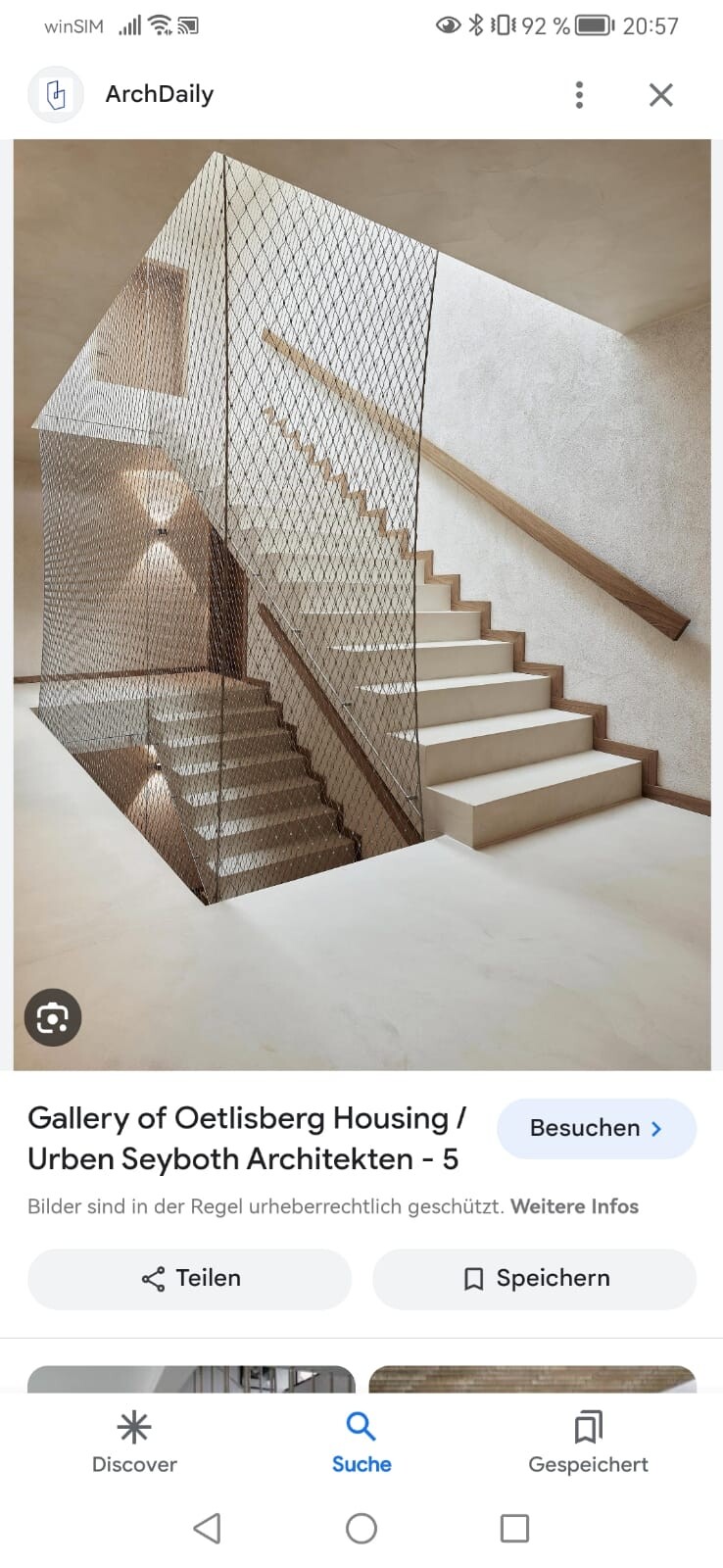 Heller Innenraum mit zwei Treppen, von Metallnetz-Geländer umgeben.