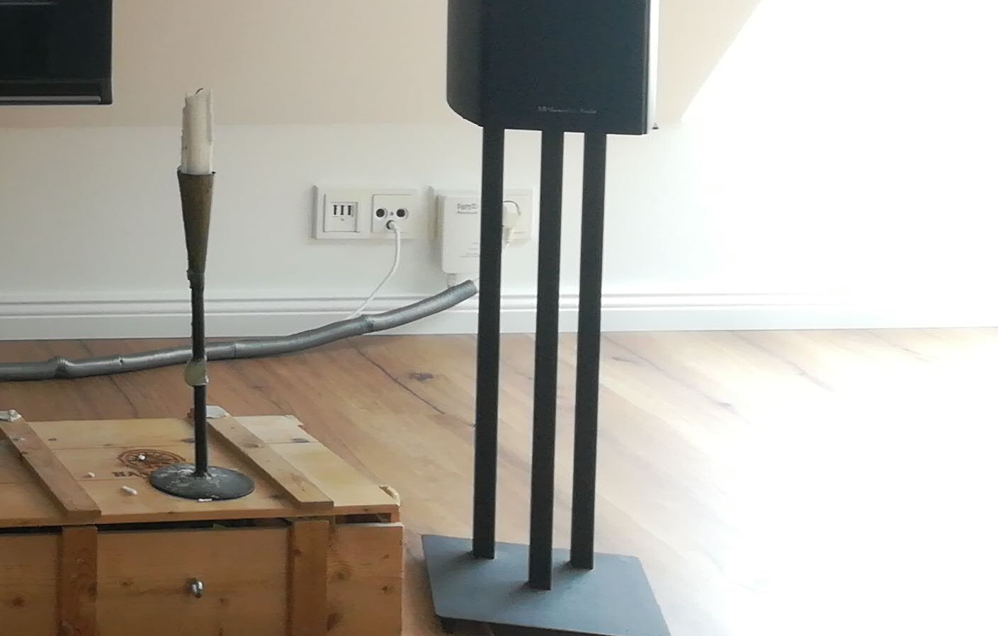 Moderne Standlampe auf Holzkiste im Wohnzimmer mit Lautsprecher und Kabeln