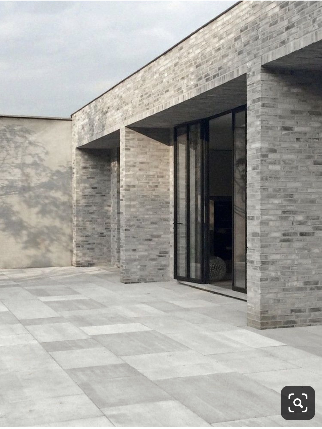 moderne-terrasse-aussenansicht-backstein-wand-glas-tuer.jpeg