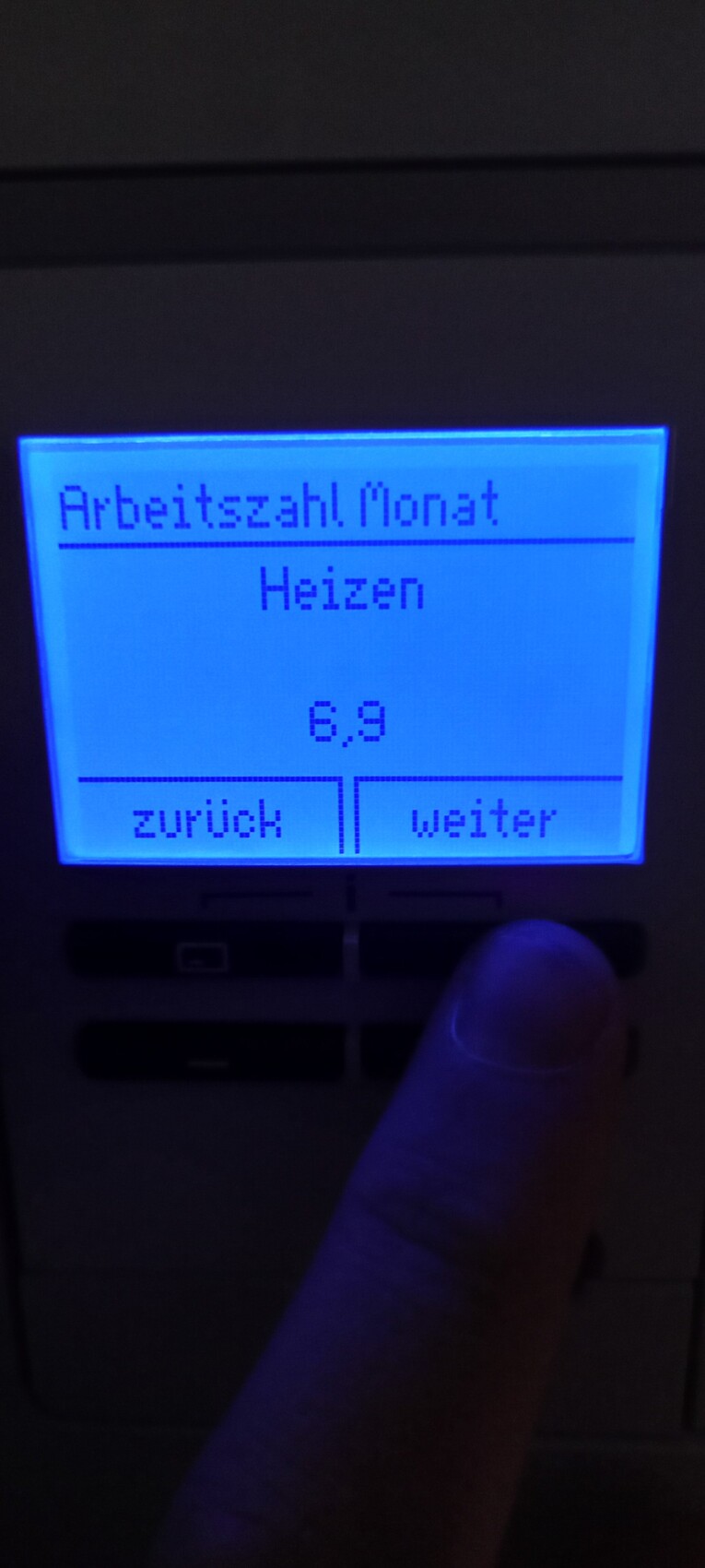 Blau beleuchtetes Heizungsdisplay zeigt Arbeitszahl Monat, Heizen, 6,9, Zurück/Weiter