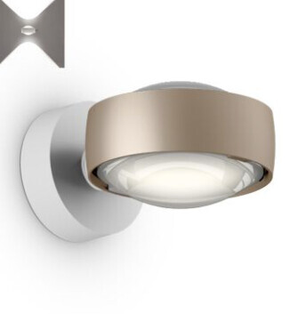 Moderne runde bronzefarbene Wandlampe mit weißem Diffusor an weißer Wand.