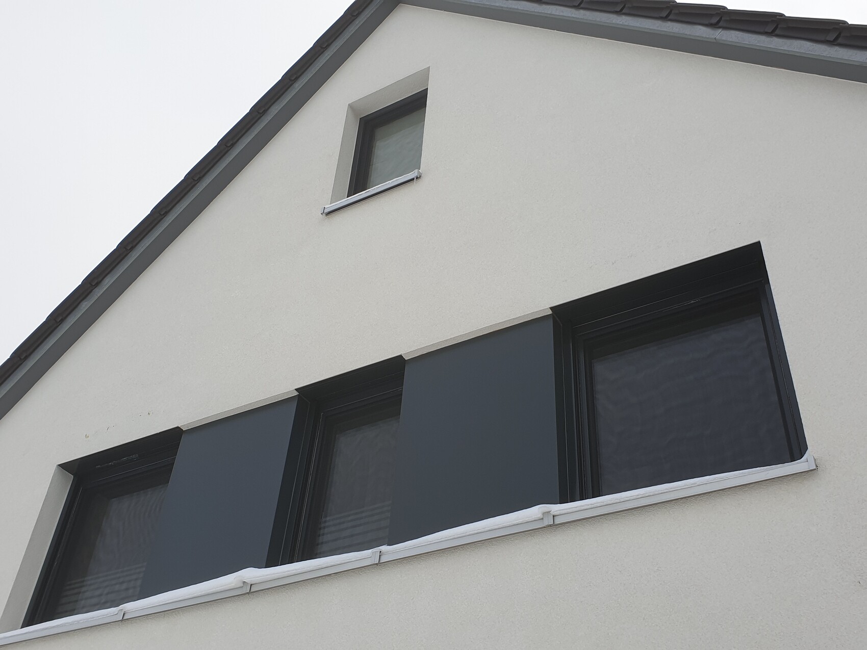 Außenansicht eines modernen weißen Hauses mit schwarzen Fensterrahmen