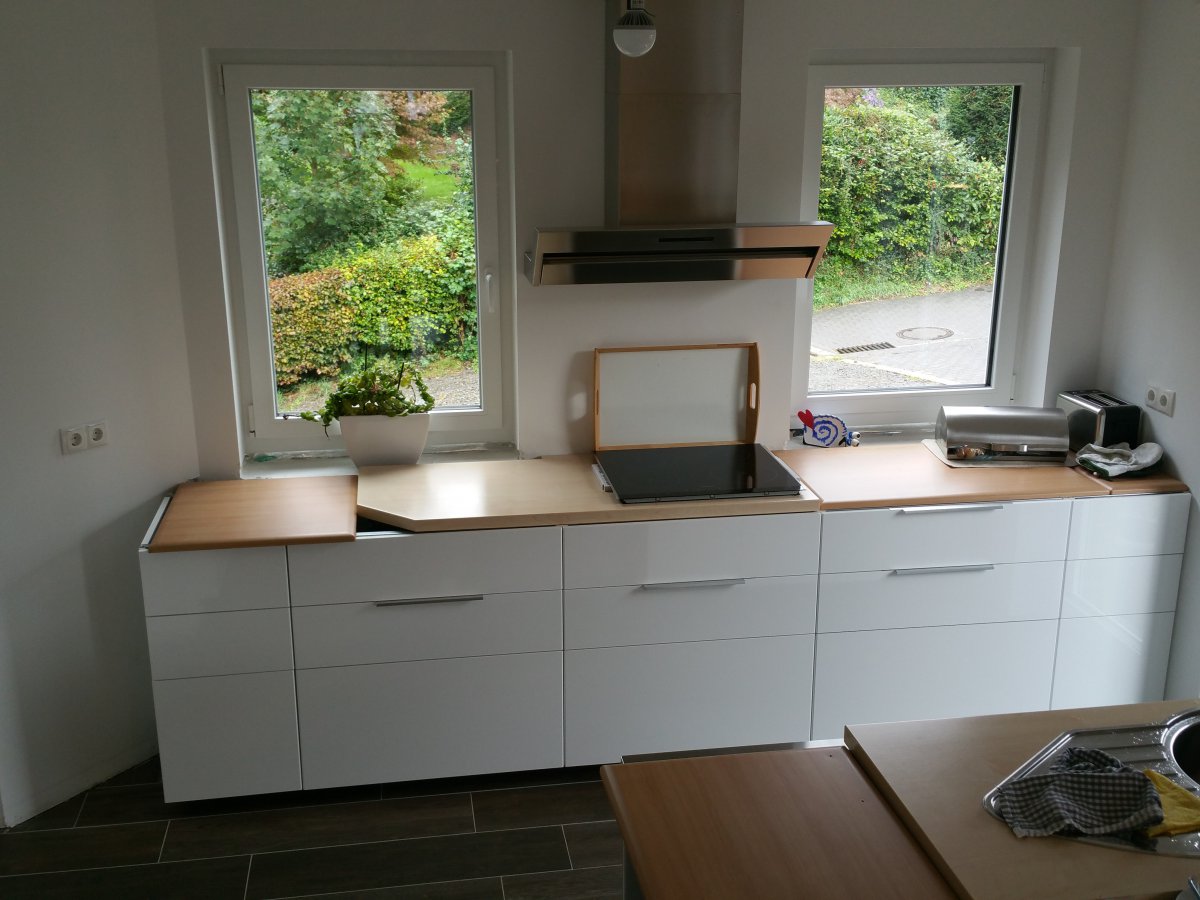 moderne-weisse-kueche-mit-induktionsherd-und-grossen-fenstern.jpg