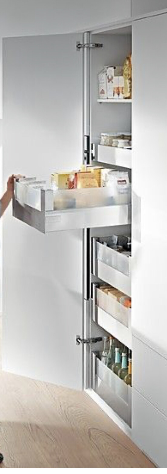 Hochschrank mit ausziehbaren Schubladen; sichtbare Vorräte, Packungen und Flaschen.