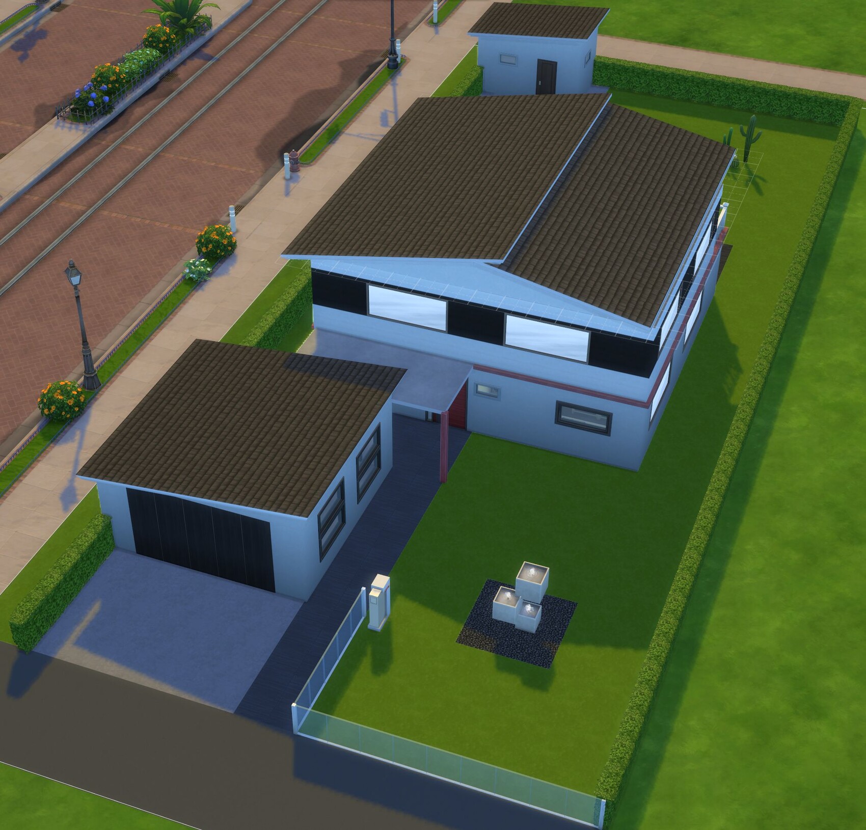 Vogelperspektive eines modernen Einfamilienhauses mit braunem Dach, weißer Fassade, Einfahrt und Garten.