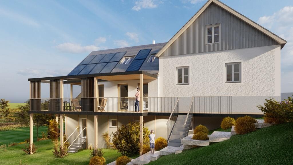 Modernes Haus mit Solarmodulen auf dem Dach, einer großen Terrasse und einem Garten