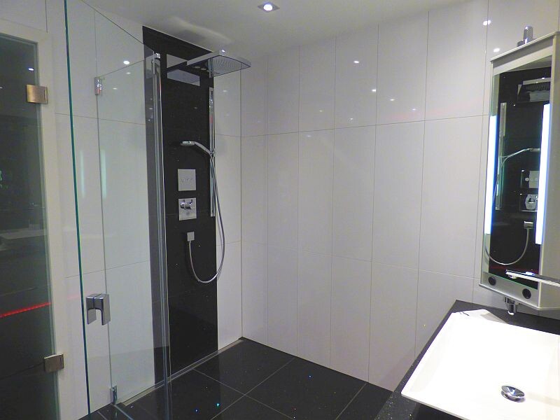 moderner-badbereich-mit-glasduschkabine-und-spiegelbeleuchtetem-spiegelschrank.JPG