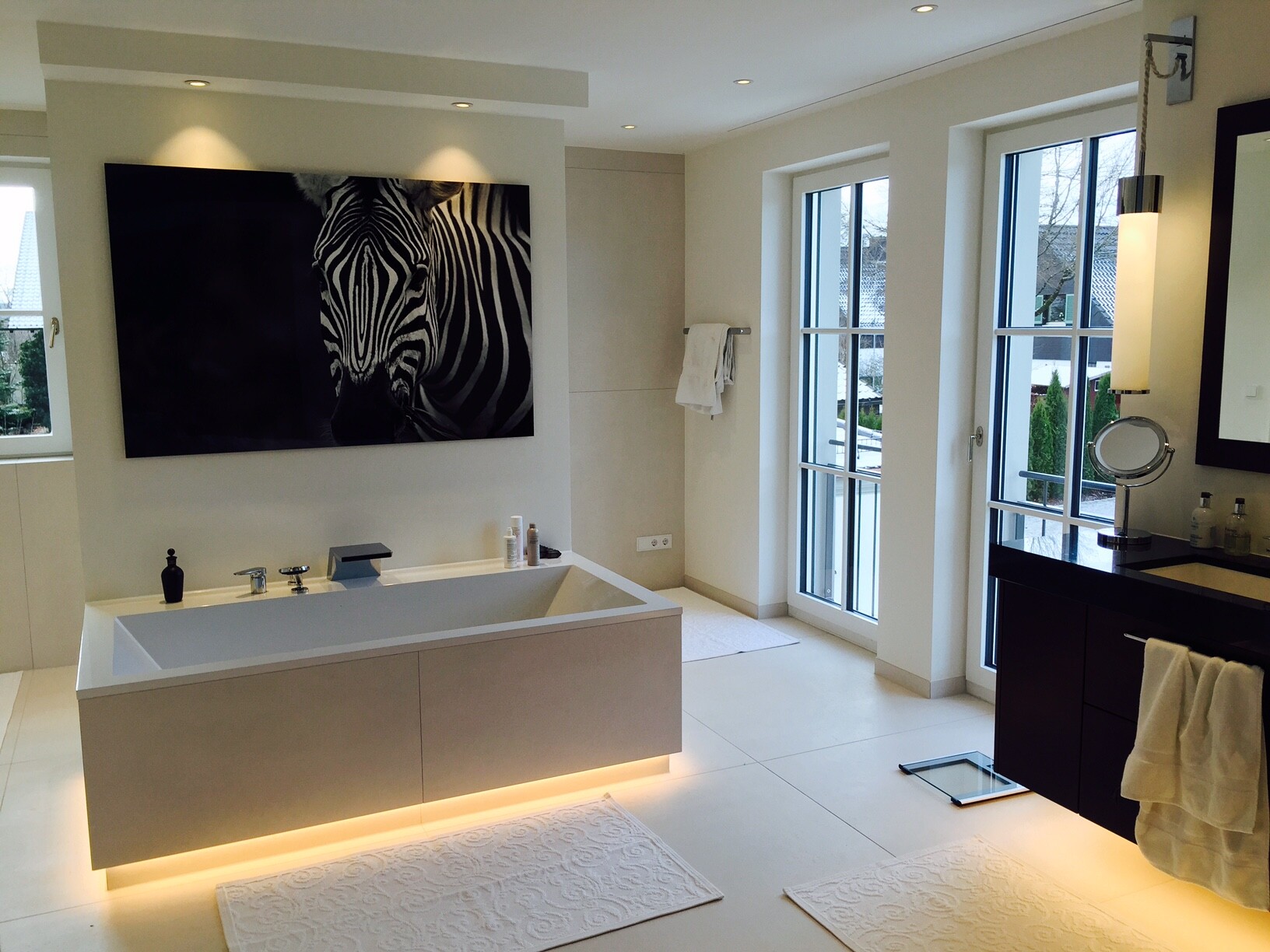 Großes modernes Badezimmer mit freistehender Badewanne, Zebra-Wandbild und bodentiefen Fenstern.