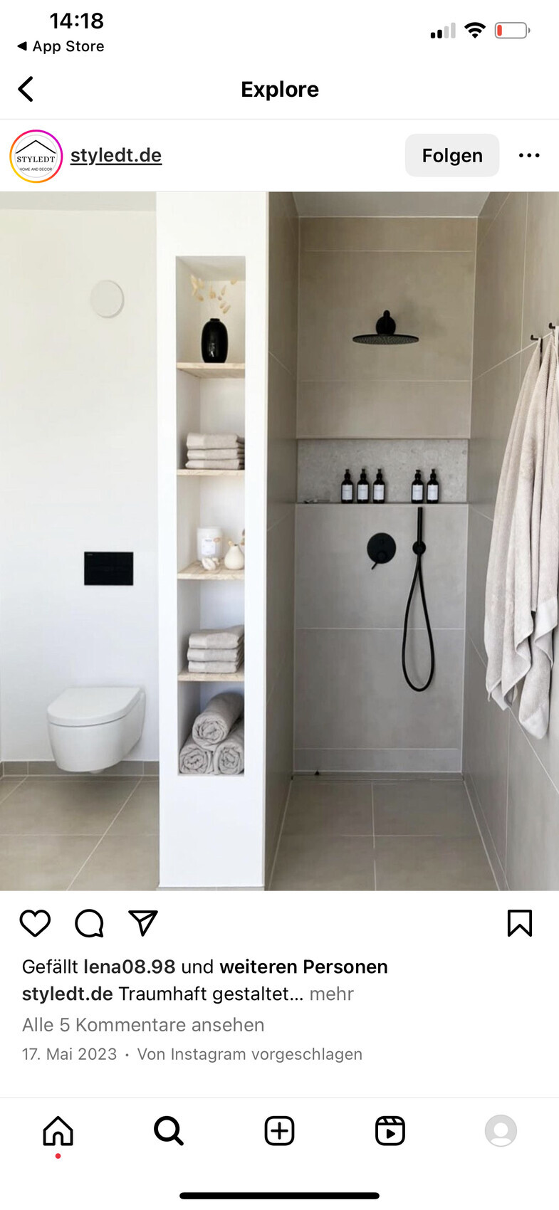 Modernes Bad: Toilette links, Regal-Nische mit Handtüchern, Dusche mit Regenduschkopf.