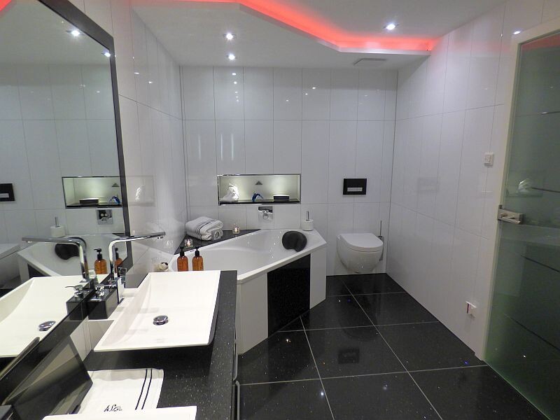 moderner-badraum-mit-badewanne-wandtoilette-glanzfliesen-led-beleuchtung.JPG