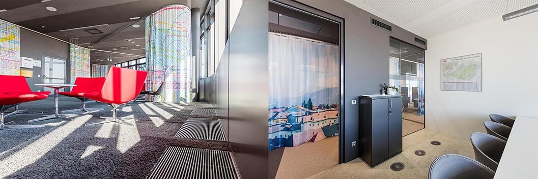 Moderne Büro-Lounge mit roten Sesseln, farbigen Säulen und Wartebereich rechts.