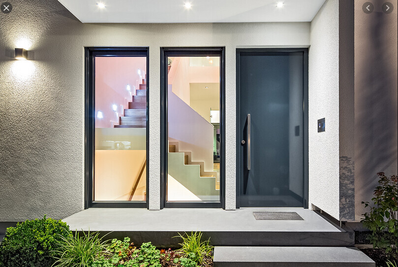 Moderne Hausfront mit drei Türen: zwei Glasfronten zeigen Treppe, rechts dunkle Eingangstür.