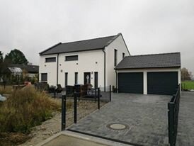 Modernes zweistöckiges Haus mit Garage und Einfahrt von vorne