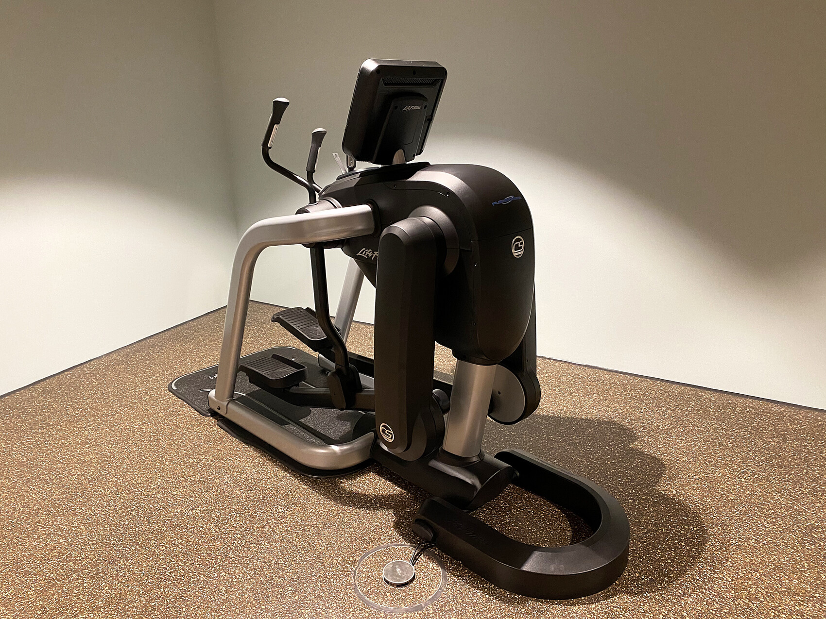 Kompakter Ellipsentrainer in hellem Fitnessraum mit Display vorne.