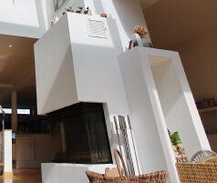 Moderner weißer Kamin im Wohnzimmer mit hellem Interieur.