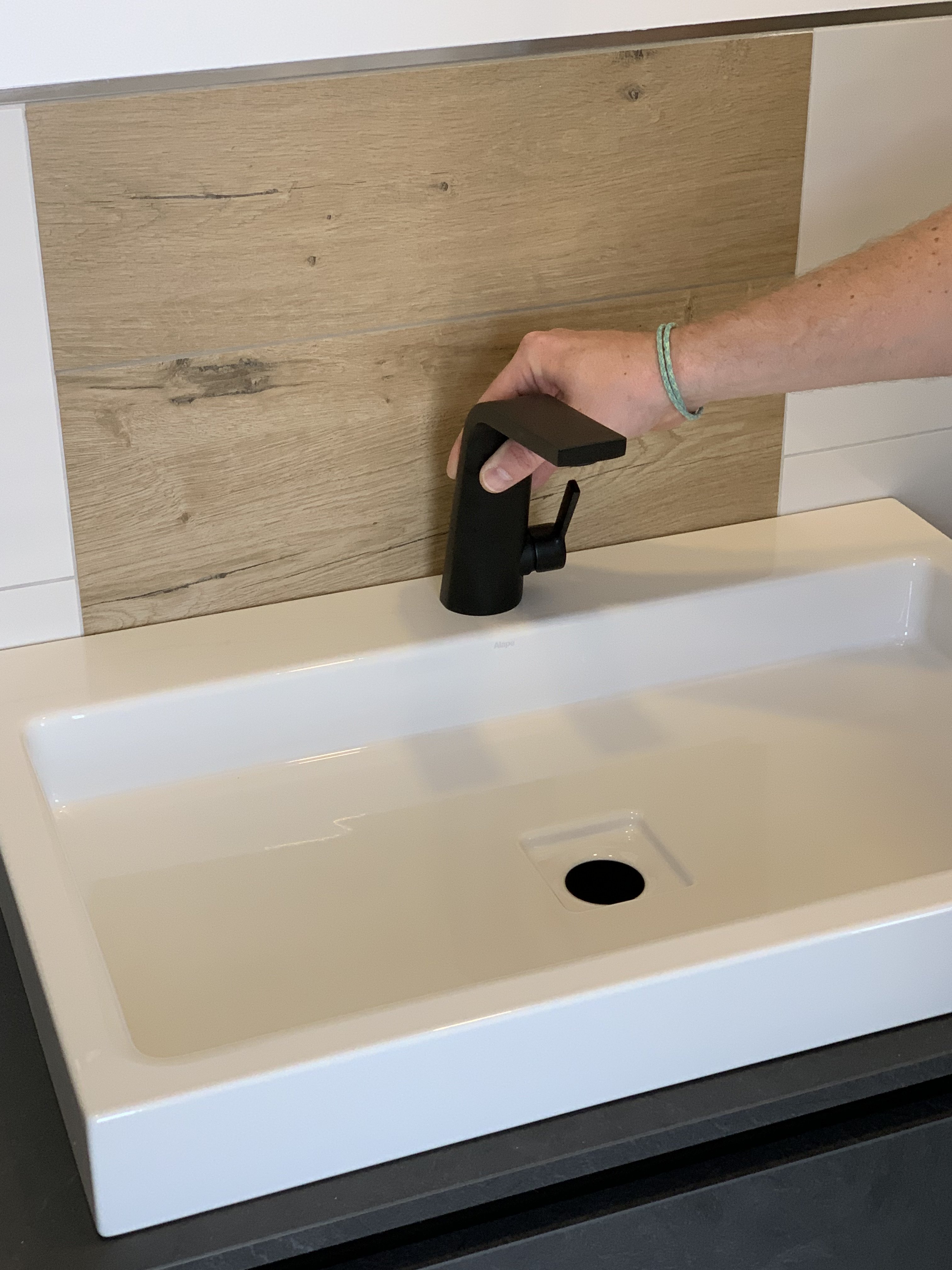 moderner-schwarzer-waschtisch-armatur-im-badezimmer-mit-holz-rueckwand.jpeg