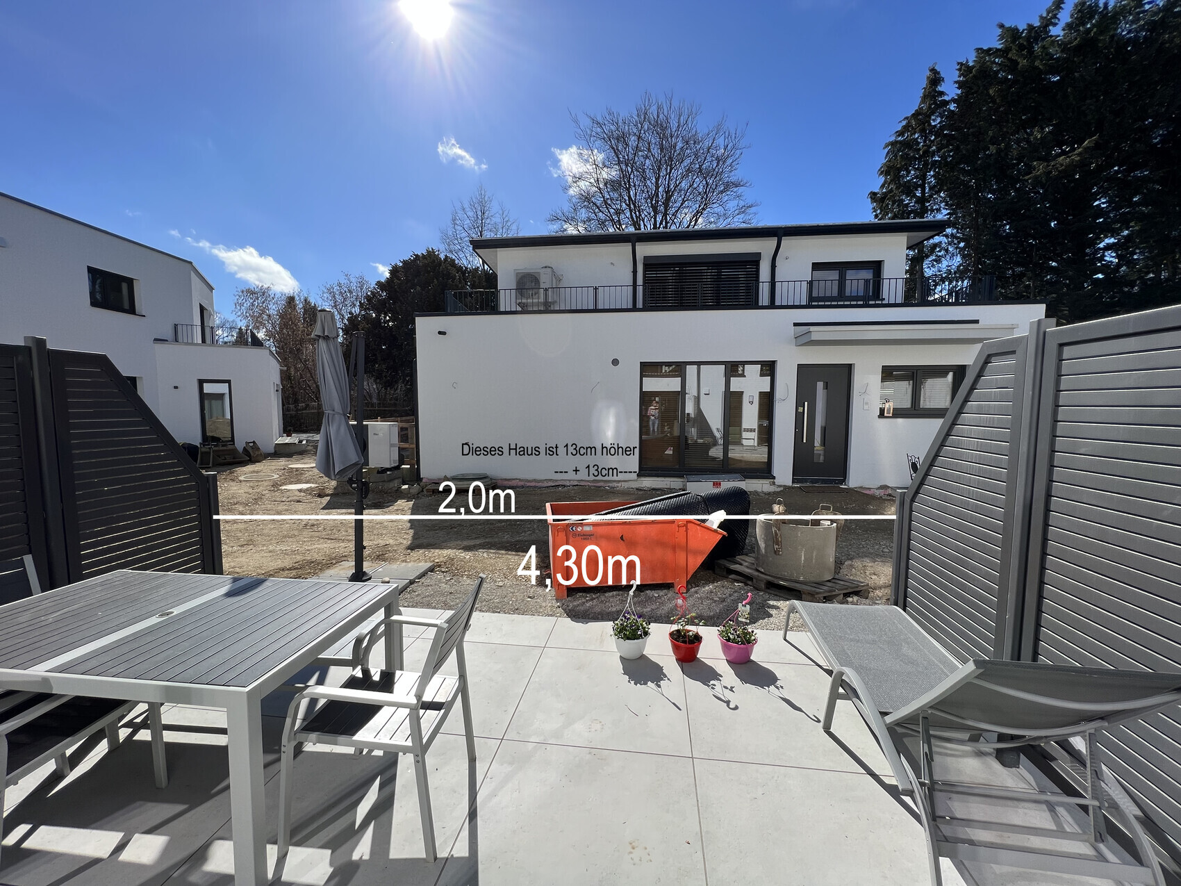 Weißes modernes Haus im Bau, Terrasse mit Möbeln; Baustelle, Messlinien 2,0 m und 4,3 m, sonnig.