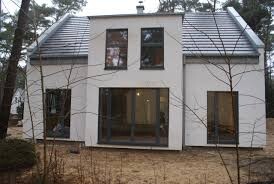 Moderne weiße Einfamilienhaus-Fassade mit großen Fenstern und Eingangstür