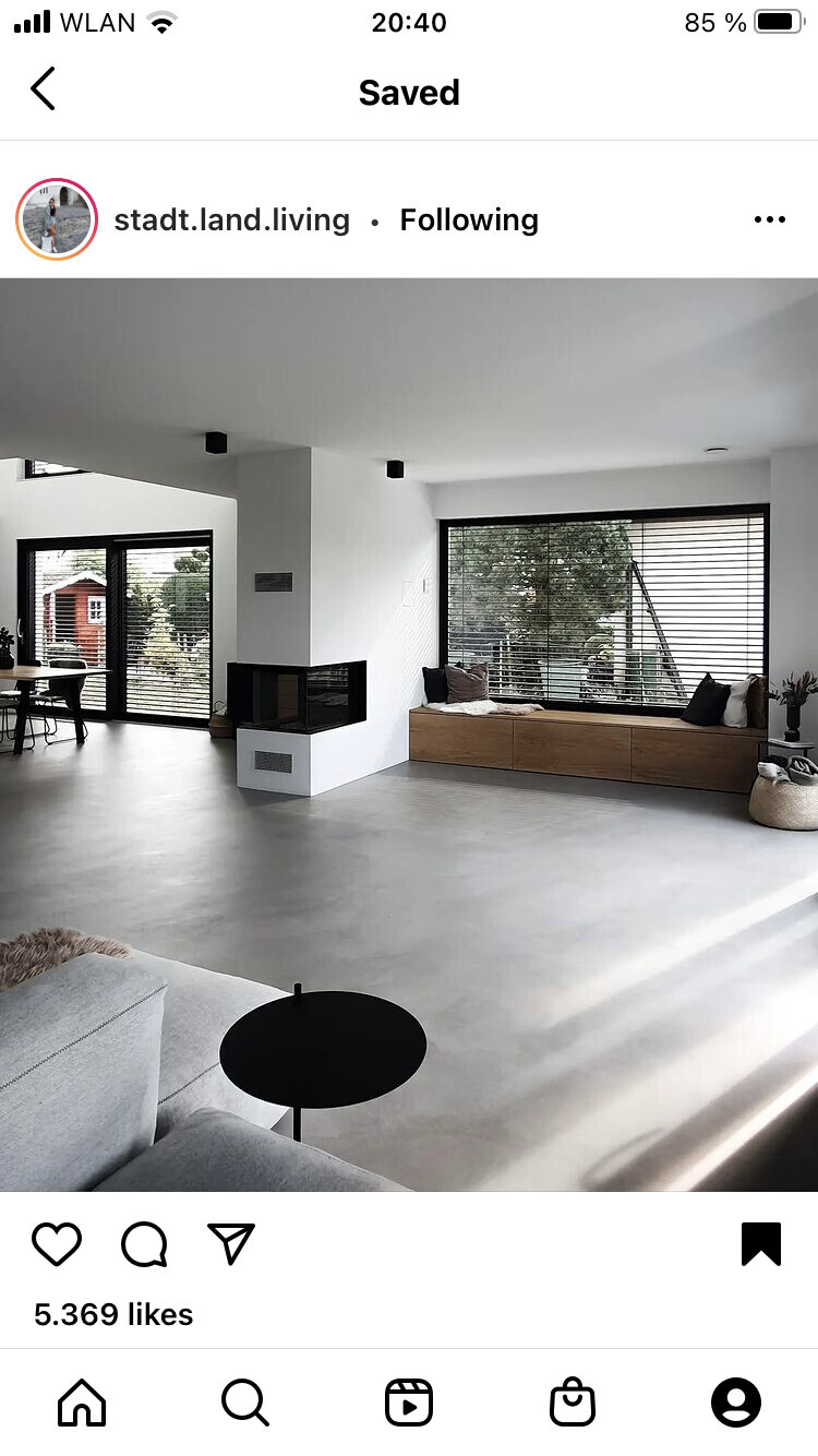 Modernes Wohnzimmer mit Kamin, weißer Wand, großer Fensterfront und Sitzbank.